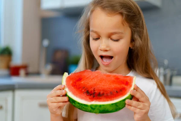 Niña comiendo sandía en la cocina — Foto de Stock