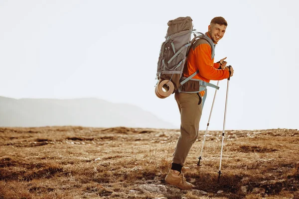Ταξιδιώτης με μπαστούνια πεζοπορίας ανεβαίνει το βουνό — Φωτογραφία Αρχείου