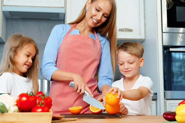 Moeder koken met haar kinderen in de keuken — Stockfoto