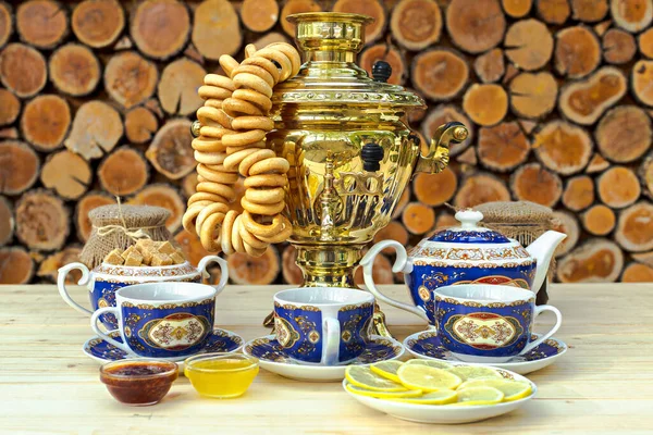Golden samovar on the table with tea set — Stock Photo, Image