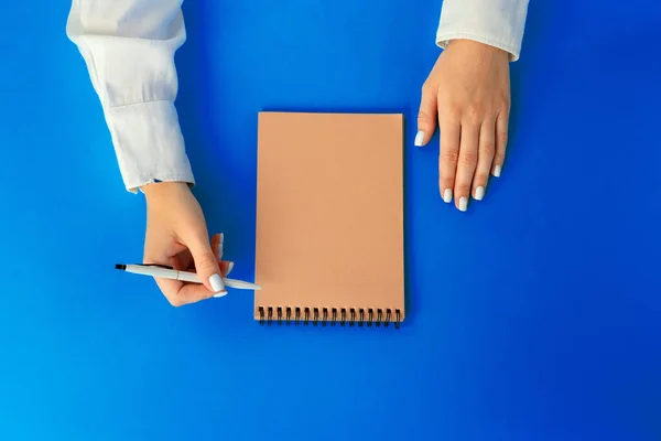 Para fazer a lista. Visão superior das mãos femininas escrevendo no caderno — Fotografia de Stock