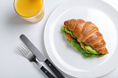 Kahvaltı için sandviç kruvasanı tabakta. Yakın plan.