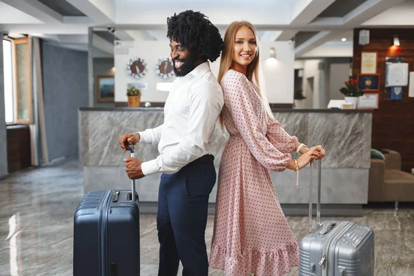Konsep perjalanan bisnis. Pria kulit hitam dan wanita Kaukasia rekan-rekan pengusaha check-in di hotel — Stok Foto