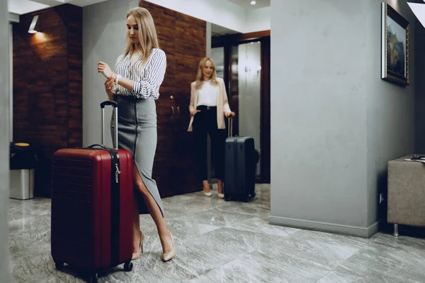 Dua wanita muda berpakaian formal memasuki lobi hotel — Stok Foto