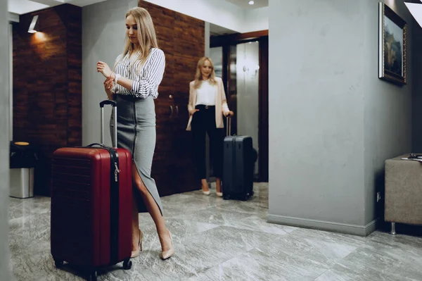 Zwei junge Frauen in formeller Kleidung betreten Hotellobby — Stockfoto