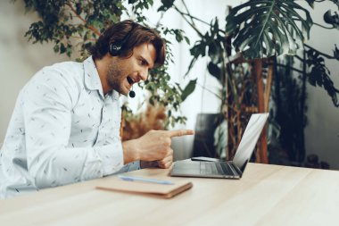 Kafkasyalı genç işadamı müşteri ortaklarıyla görüntülü görüşme yapıyor.