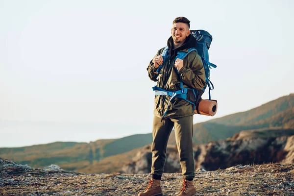 Young caucasian man traveler with big backpack hiking in the mountains — Stock Photo, Image