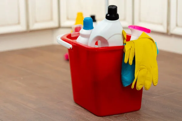 Διάφορα οικιακά απορρυπαντικά και μπουκάλια καθαρισμού σε έναν πλαστικό κουβά στο πάτωμα — Φωτογραφία Αρχείου