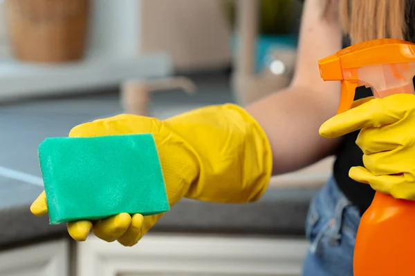 Руки женщины в жёлтых перчатках, держащей зелёную губку — стоковое фото
