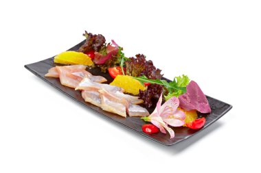 Beyaz salatayla servis edilen tuzlu ringa parçaları.