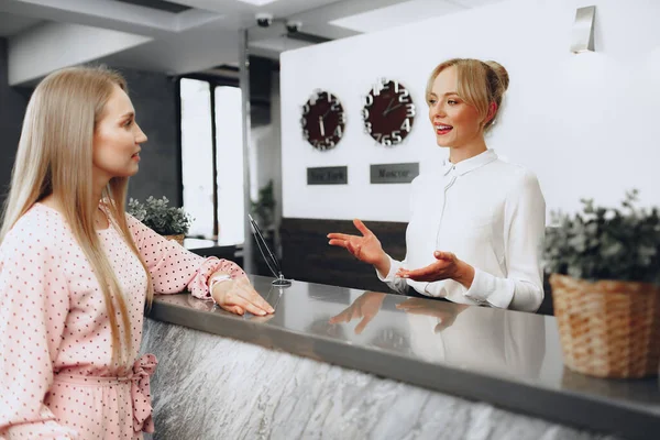 Check-in degli ospiti dell'hotel per donne bionde alla reception dell'hotel — Foto Stock