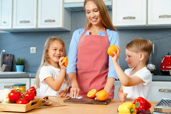 Mãe cozinhar com seus filhos na cozinha — Fotografia de Stock