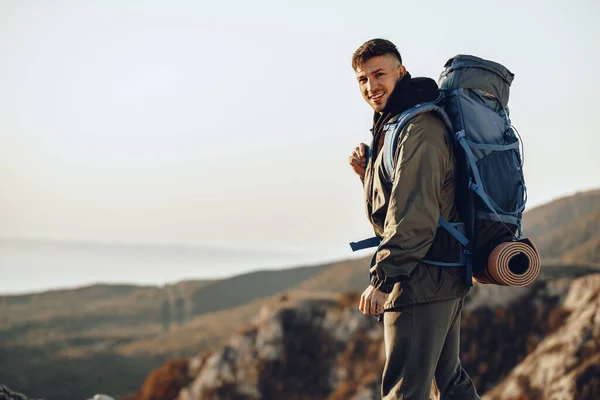 stock image Young caucasian man traveler with big backpack hiking in the mountains