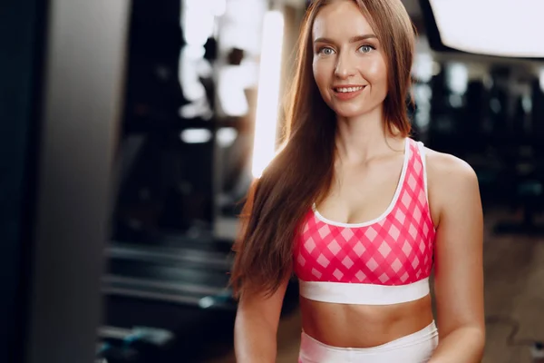 Ung vacker kvinna i sportkläder i ett gym — Stockfoto