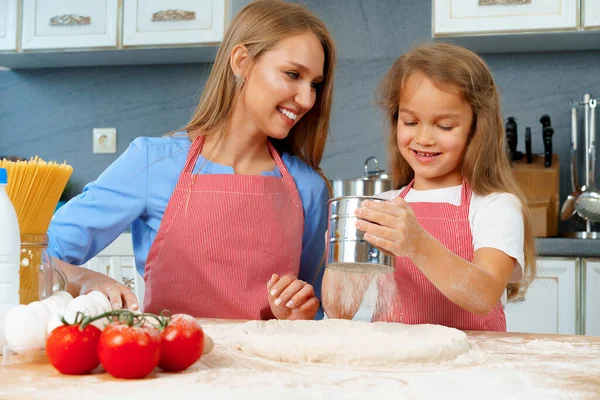 Mãe e sua filhinha preparando massa na cozinha — Fotografia de Stock