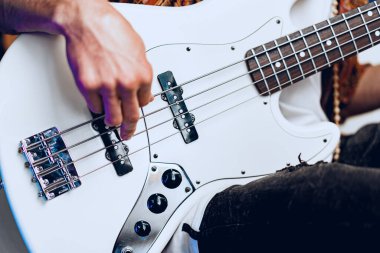 Erkek ellerinin gitar çalarken çekilmiş bir fotoğrafı.
