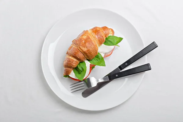 Smörgås croissant i tallrik för frukost närbild — Stockfoto