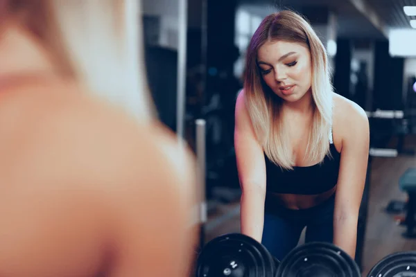 Curvy ταιριάζει νεαρή ξανθιά γυναίκα ανύψωση αλτήρα σε ένα γυμναστήριο — Φωτογραφία Αρχείου
