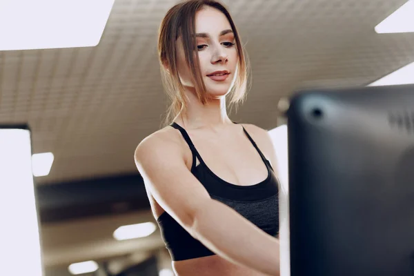 Ziemlich fitte Frau im schwarzen Sportanzug beim Training auf dem Laufband — Stockfoto