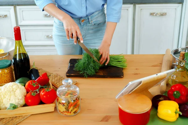 Молодая блондинка-кавказка режет овощи для салата на кухне — стоковое фото