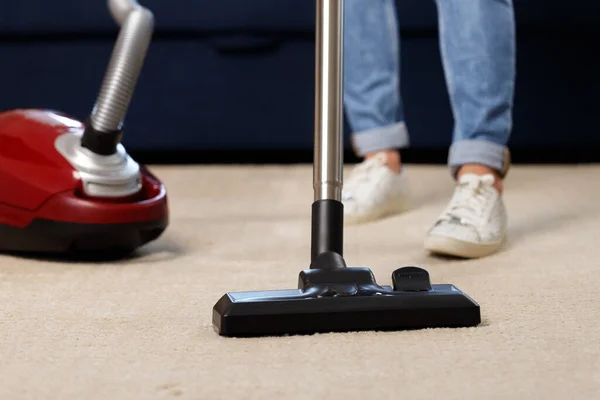 Primer plano de una mujer que limpia al vacío la alfombra — Foto de Stock