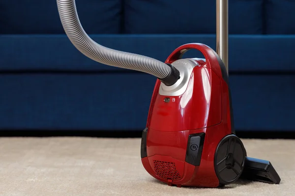 Red vacuum cleaner di karpet krem — Stok Foto