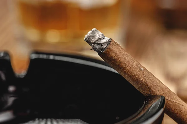 Cigarro encendido en un cenicero de cerca — Foto de Stock