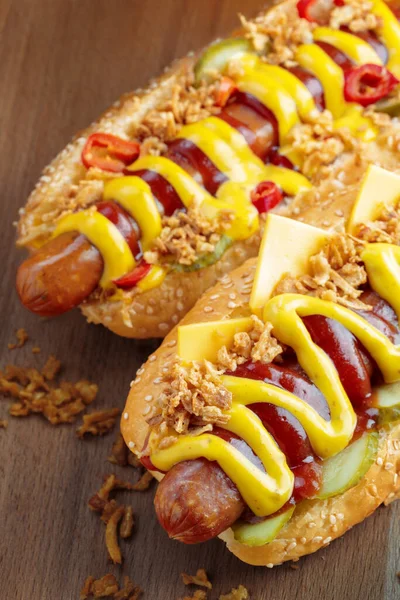 Hot dog se žlutou hořčicí a kečupem na dřevěné desce — Stock fotografie