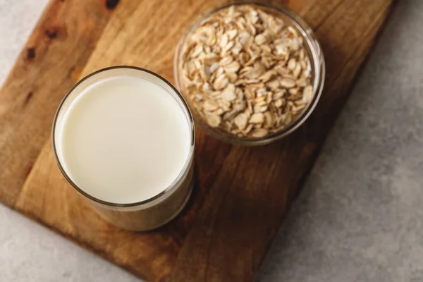 Vegan oat milk with oat flakes close up