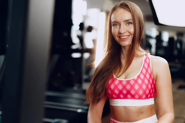 Joven hermosa mujer en ropa deportiva en un gimnasio —  Fotos de Stock