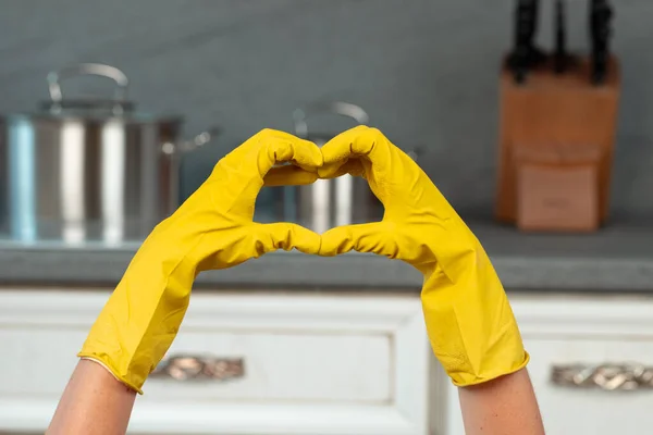 Ręce w żółtych rękawiczkach na tle kuchni. Koncepcja utrzymania porządku — Zdjęcie stockowe