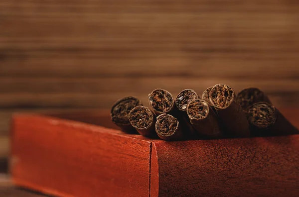 Röd trälåda med rullade cigarrer på träbord på nära håll — Stockfoto