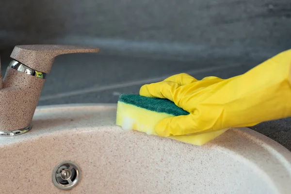 Hands in yellow gloves cleaning a sink with a sponge — Stock Photo, Image