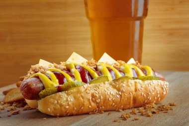 Tahtada sarı hardallı ve ketçaplı sosisli sandviç.