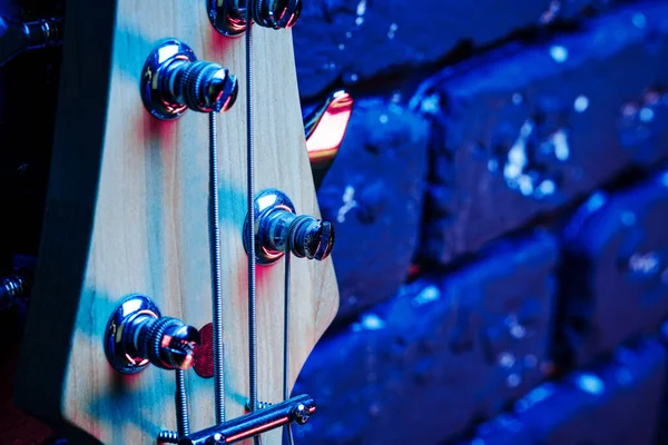 Guitar headstock with tuners on dark background