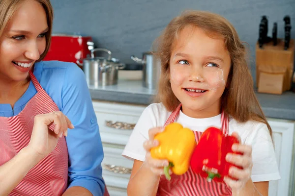 Mooie moeder en haar schattige dochter hebben plezier in de keuken tijdens het koken eten — Stockfoto