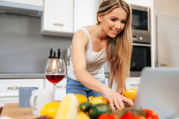 Jovem mulher bonita cozinhar algo em sua cozinha — Fotografia de Stock