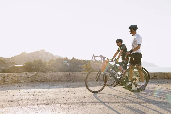 Due ciclisti maschi stanno sulla strada e si riposano — Foto Stock