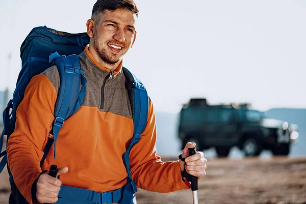 Man traveler with trekking sticks going up the mountain — Stock Photo, Image