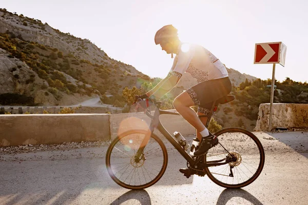Corridore professionista di biciclette da strada in azione su strada di montagna — Foto Stock