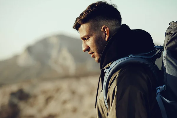 Young caucasian man traveler with big backpack hiking in the mountains — Stock Photo, Image