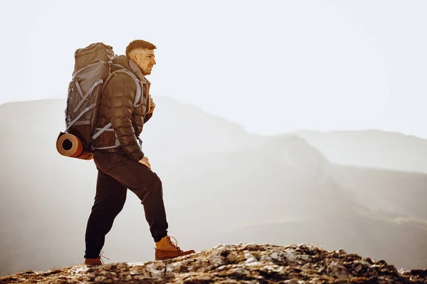 Чоловічий рюкзак у туристичному обладнанні, що стоїть на вершині гори — стокове фото