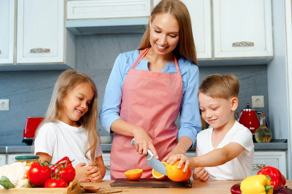 Moeder koken met haar kinderen in de keuken — Stockfoto