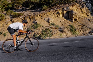 Dağ yolunda profesyonel bir bisiklet yarışçısı var.