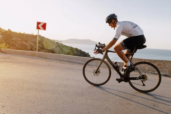 Kıyı yolunda bisiklet süren sporcu.