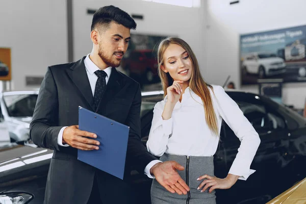 Homem carro revendedor mostrando uma mulher comprador um novo carro — Fotografia de Stock