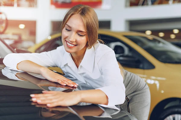 Schöne junge Frau berührt ihr neues Auto mit Vergnügen — Stockfoto