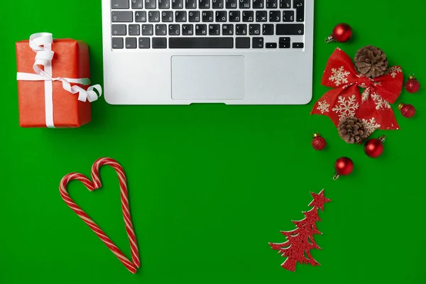 Dekoracje świąteczne i laptop na papierowym tle — Zdjęcie stockowe