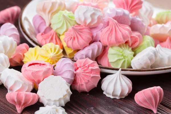 Kleurrijke zoete meringue koekjes assortiment op houten tafel — Stockfoto