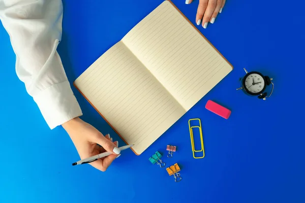 Pour faire la liste. Vue du dessus des mains féminines écrivant dans un cahier — Photo